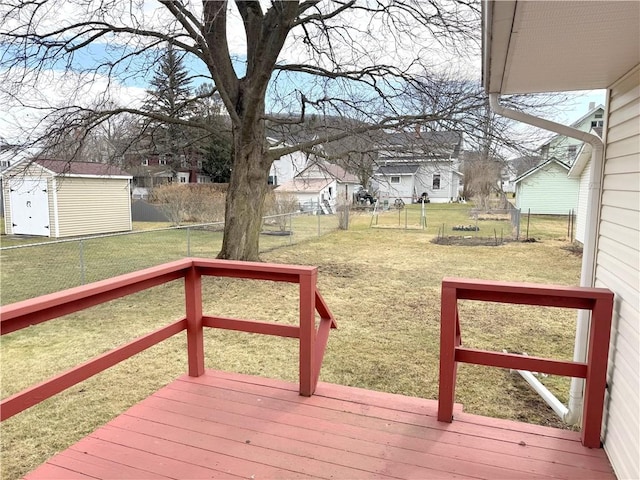 wooden deck with a fenced backyard, a residential view, a lawn, and an outdoor structure