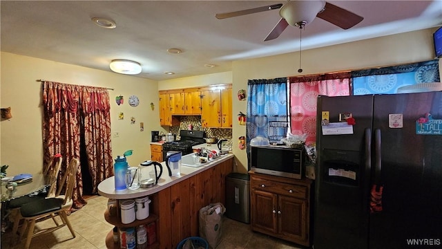 kitchen featuring light tile patterned floors, tasteful backsplash, light countertops, a peninsula, and black appliances