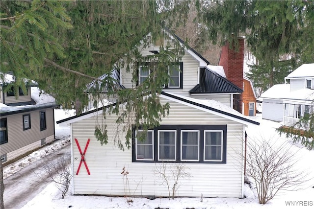 snow covered property with a chimney