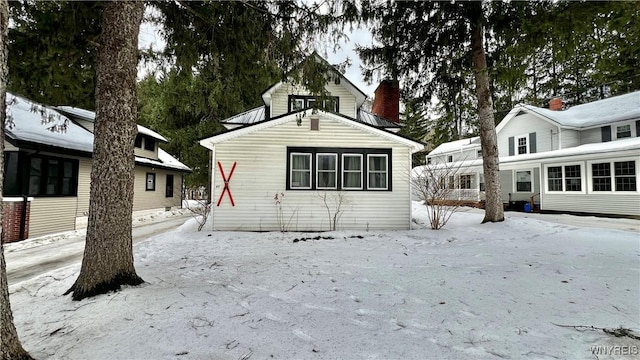 snow covered property featuring a chimney