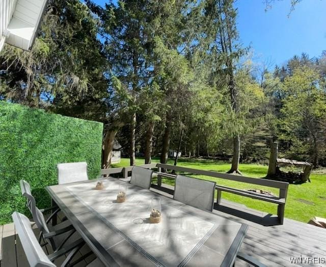 deck featuring a yard and outdoor dining space