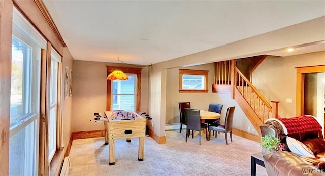 interior space with baseboards, baseboard heating, and light colored carpet