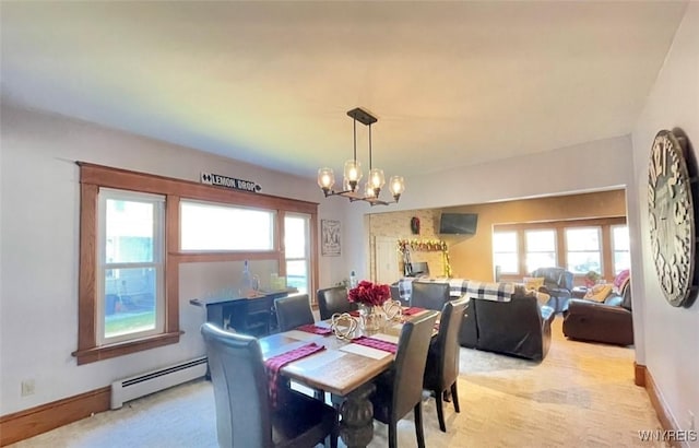 dining area featuring a baseboard heating unit, a chandelier, light carpet, and baseboards