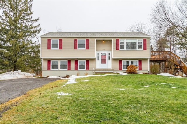 bi-level home with driveway and a front lawn