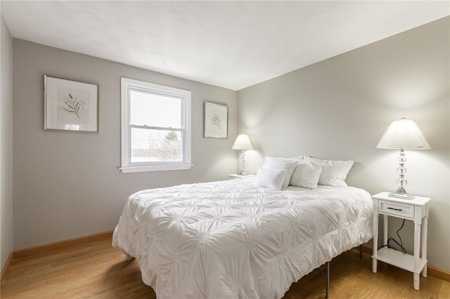 bedroom featuring baseboards and wood finished floors