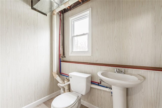 half bathroom with toilet and baseboards