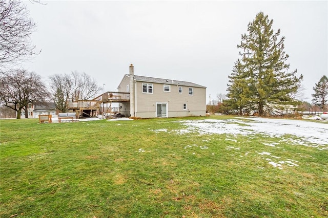 back of house with a chimney, a lawn, and a wooden deck