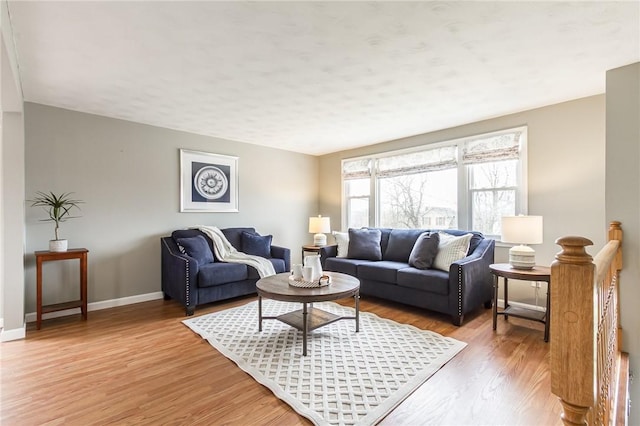 living area featuring light wood-style floors and baseboards