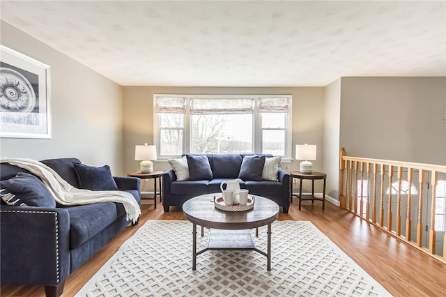 living area with baseboards and wood finished floors