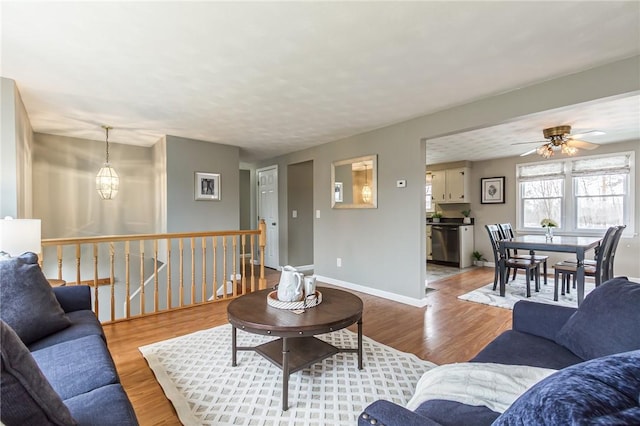 living area with a chandelier, wood finished floors, and baseboards