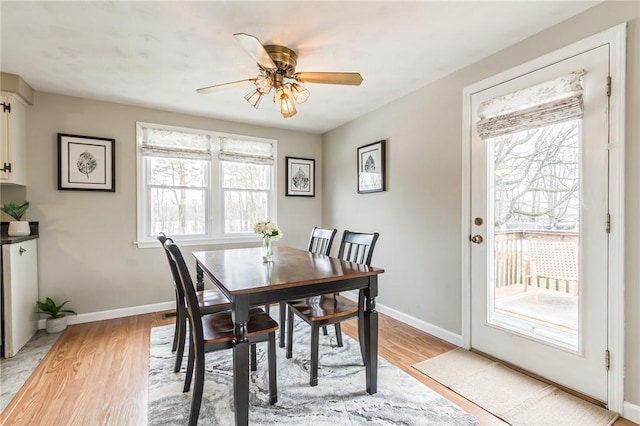 dining space with light wood finished floors, ceiling fan, and baseboards