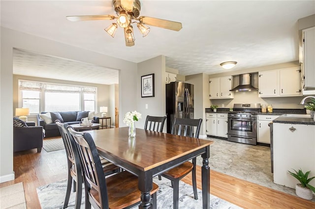 dining area featuring light wood-style flooring and a ceiling fan