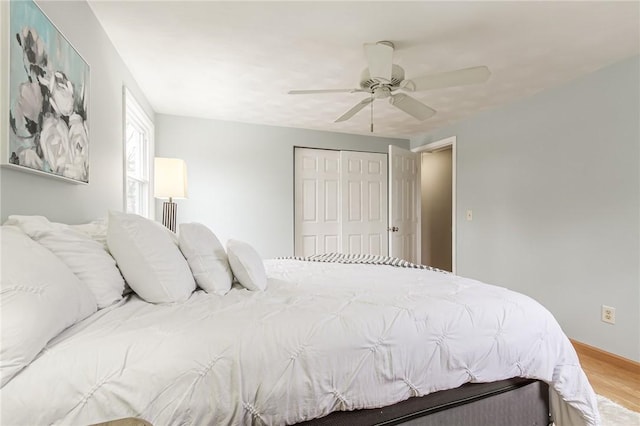 bedroom featuring a ceiling fan, a closet, and wood finished floors