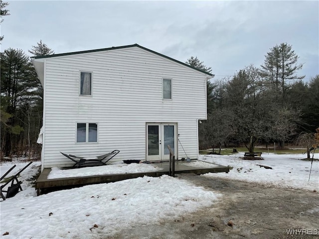 snow covered property with french doors