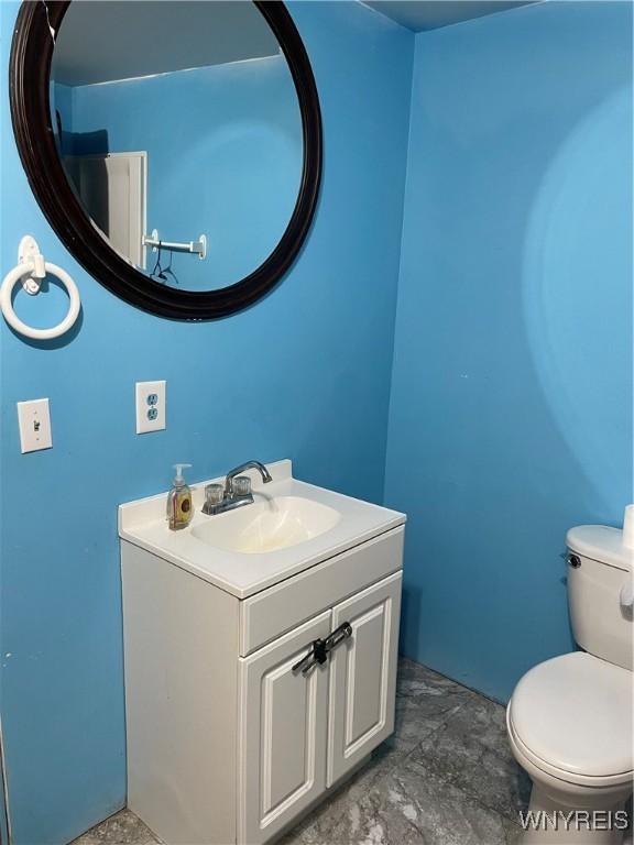 half bath featuring toilet and vanity