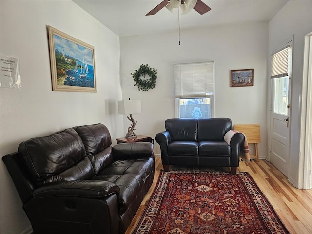 living area with light wood finished floors, ceiling fan, and a wealth of natural light