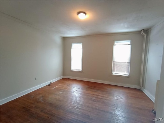 empty room with wood-type flooring and baseboards