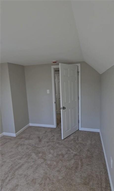 additional living space featuring carpet floors, lofted ceiling, and baseboards