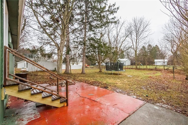 view of yard with a fenced backyard, a trampoline, and a patio