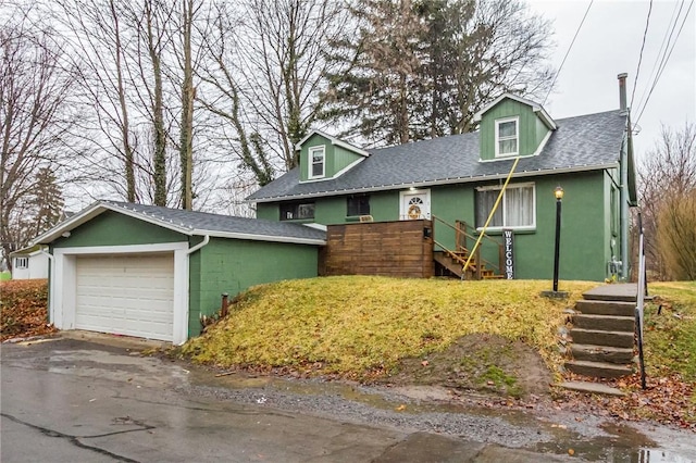 view of front of property with a garage, driveway, a shingled roof, and stucco siding