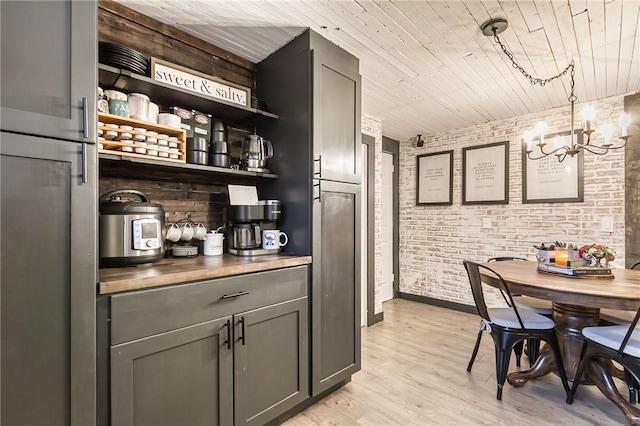 bar featuring brick wall, wooden ceiling, an inviting chandelier, and light wood-style floors