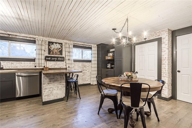 dining area with wood ceiling, light wood-style floors, brick wall, and a chandelier