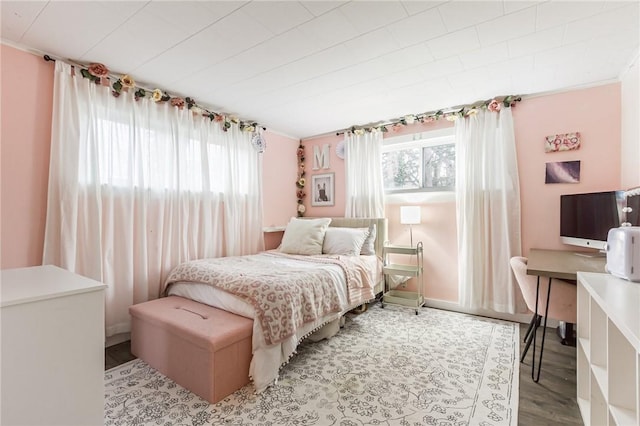 bedroom with wood finished floors and baseboards