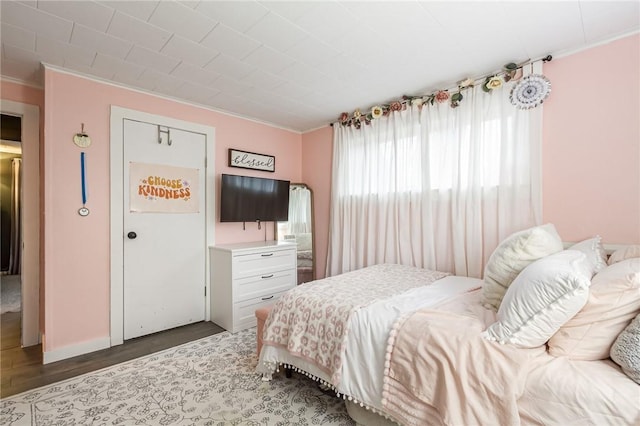 bedroom with crown molding and wood finished floors