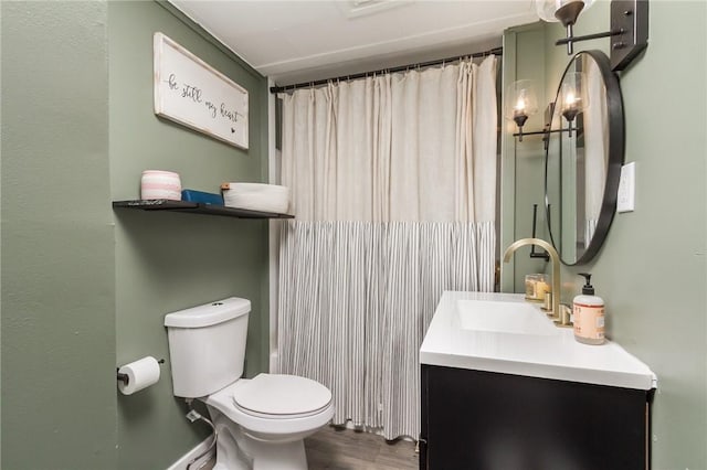 bathroom featuring toilet, wood finished floors, and vanity