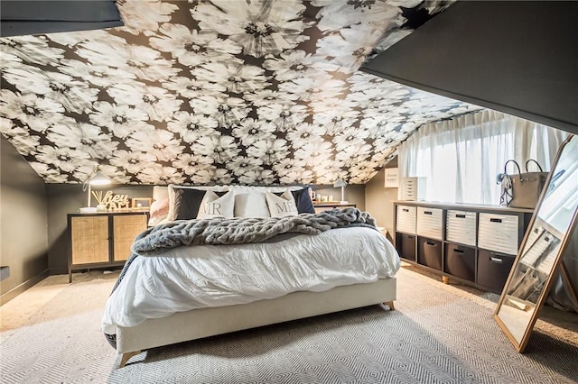 carpeted bedroom with lofted ceiling and baseboards