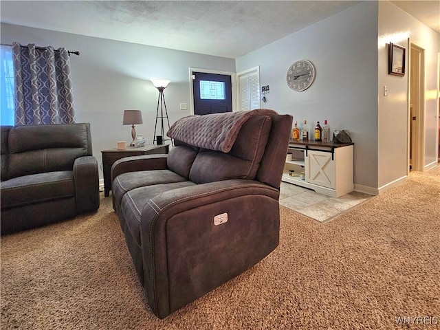 living room with a textured ceiling, carpet, and baseboards