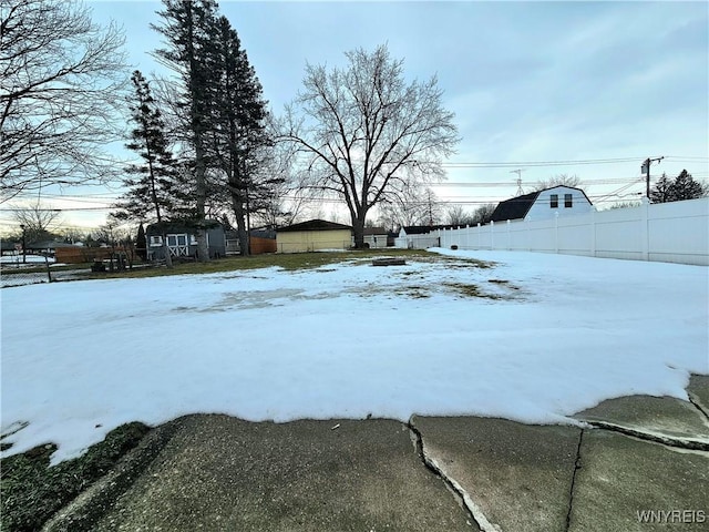 yard covered in snow featuring fence