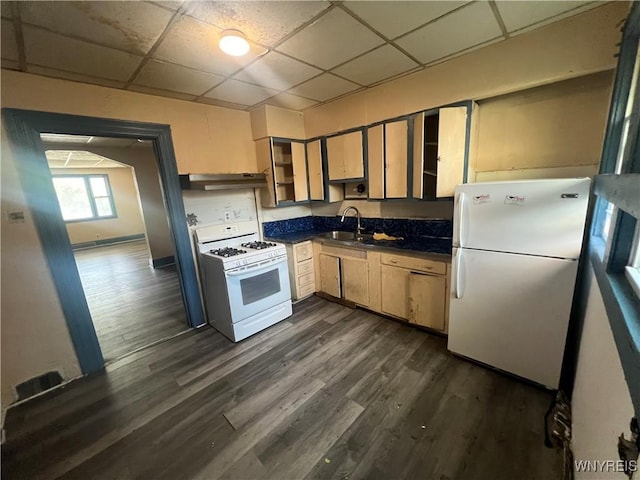 kitchen featuring a paneled ceiling, dark countertops, a sink, white appliances, and under cabinet range hood