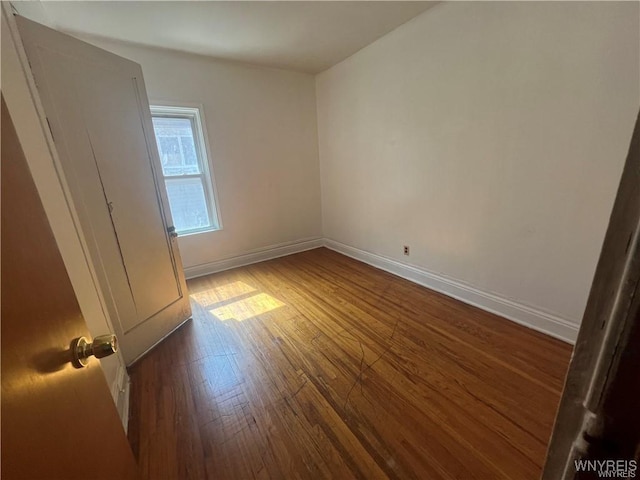 unfurnished bedroom featuring dark wood finished floors and baseboards