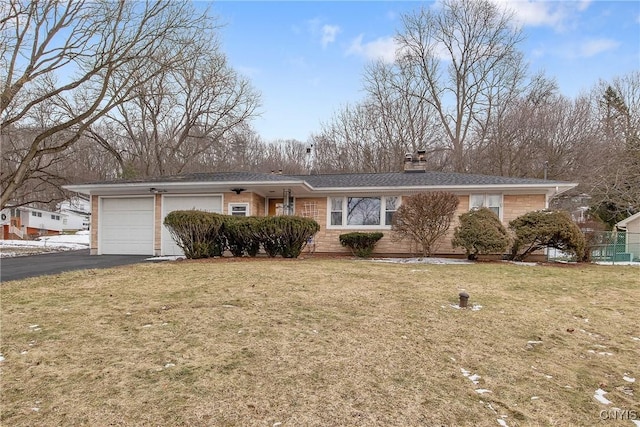 single story home featuring aphalt driveway, a front yard, a chimney, and a garage