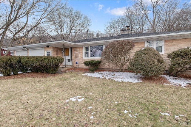 ranch-style home with an attached garage, a chimney, and a front yard