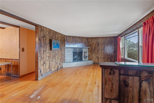 unfurnished living room featuring a fireplace, light wood-style flooring, and baseboards