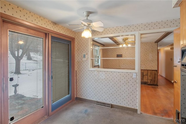 interior space featuring wallpapered walls, ceiling fan, visible vents, and baseboards