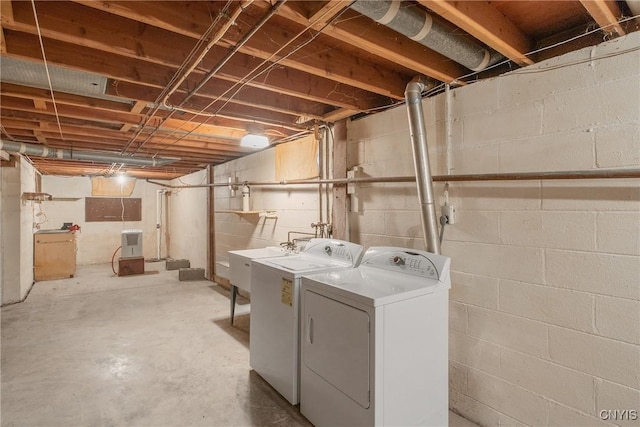 clothes washing area with washing machine and dryer, laundry area, and a sink