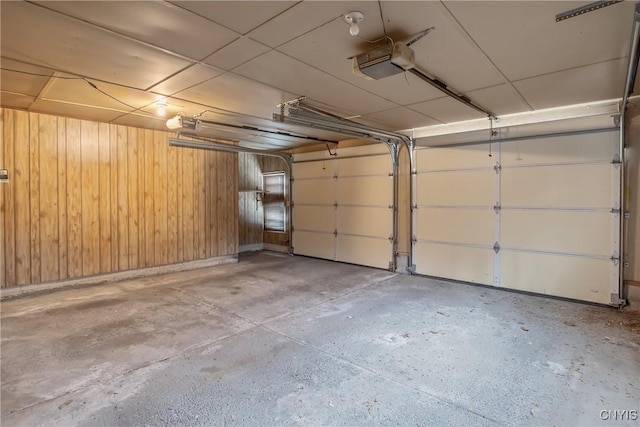 garage featuring wood walls and a garage door opener