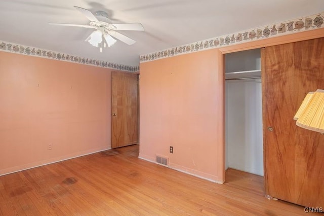 unfurnished bedroom with baseboards, visible vents, ceiling fan, light wood-type flooring, and a closet