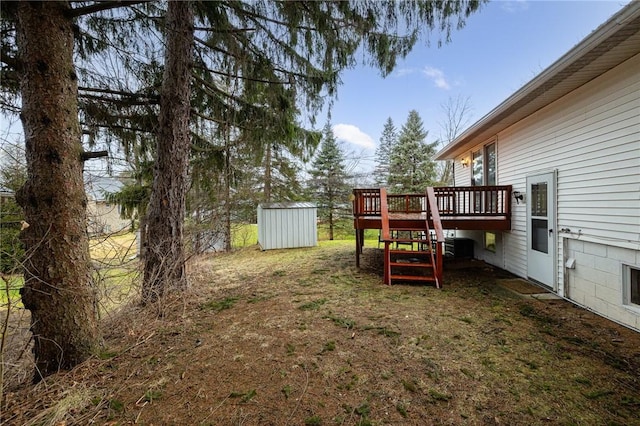 view of yard with an outbuilding, a storage shed, a deck, and stairway