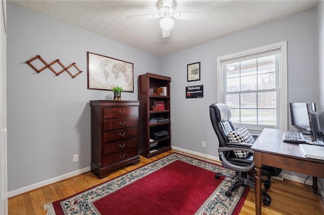 office featuring ceiling fan, a textured ceiling, wood finished floors, and baseboards