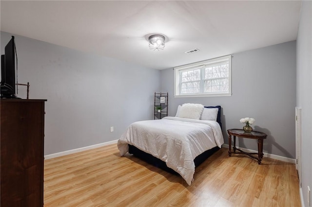 bedroom with visible vents, light wood-style flooring, and baseboards