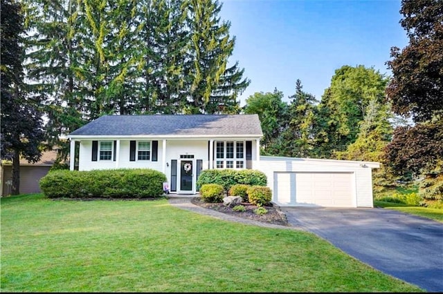 bi-level home with a garage, aphalt driveway, and a front yard