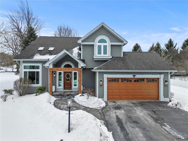 view of front of home featuring driveway, an attached garage, and roof with shingles