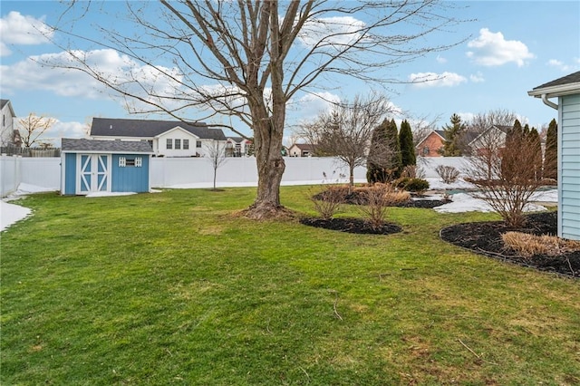 view of yard with a shed, an outdoor structure, and a fenced backyard