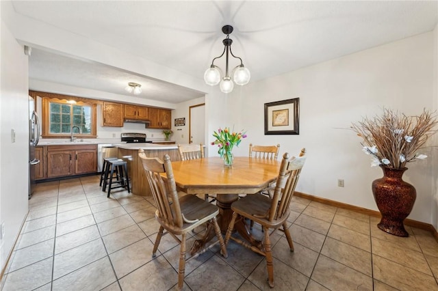 dining space featuring a notable chandelier, baseboards, and light tile patterned floors