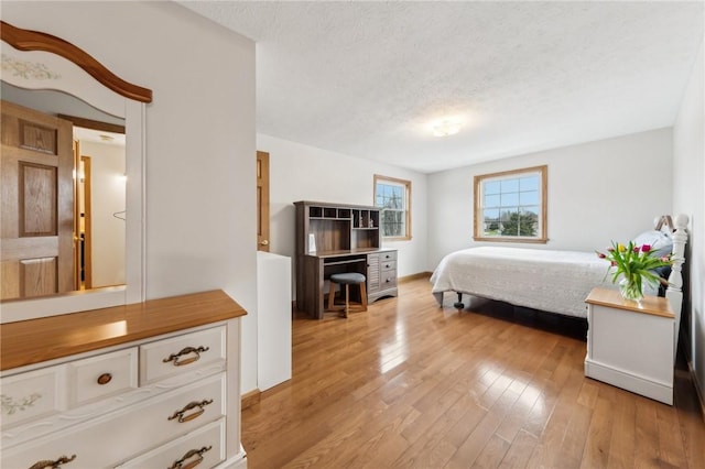 bedroom with light wood-style flooring and a textured ceiling