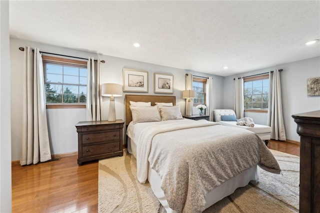 bedroom with recessed lighting, wood finished floors, and baseboards